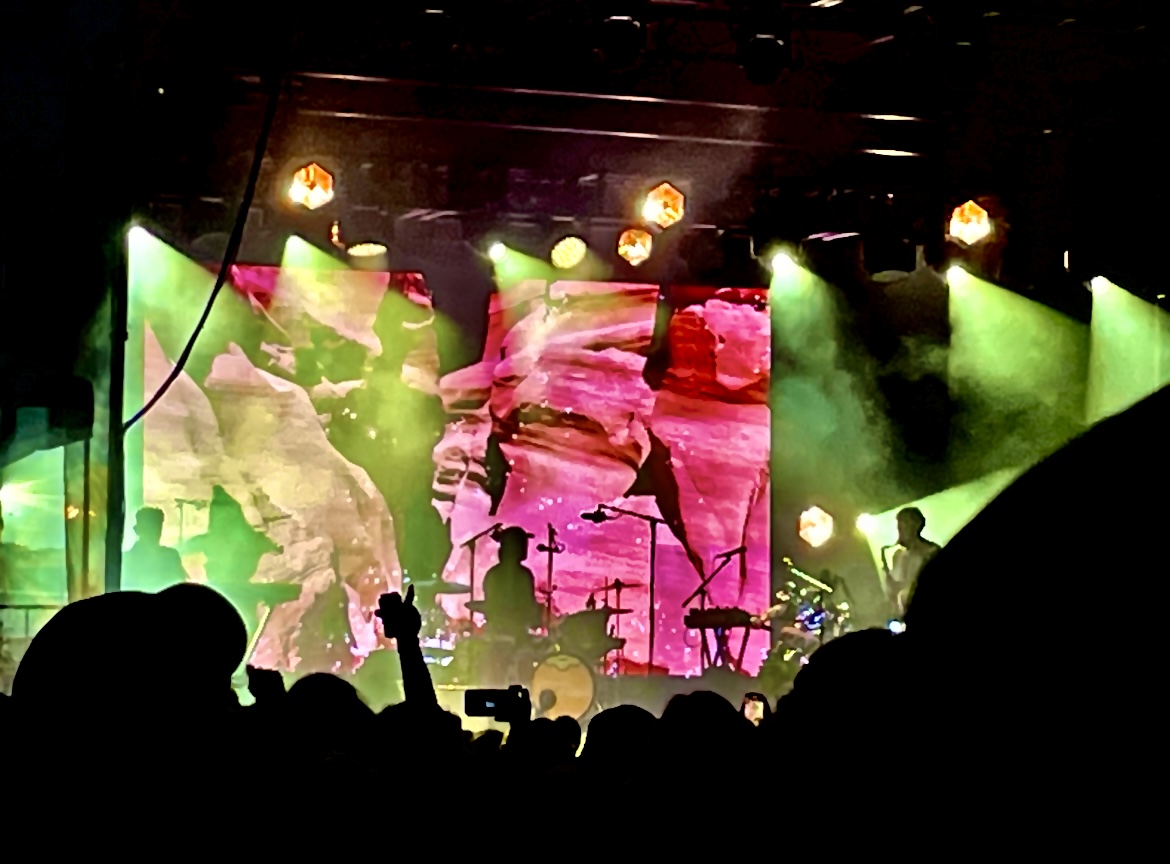 A band silhouetted onstage with the audience in the foreground